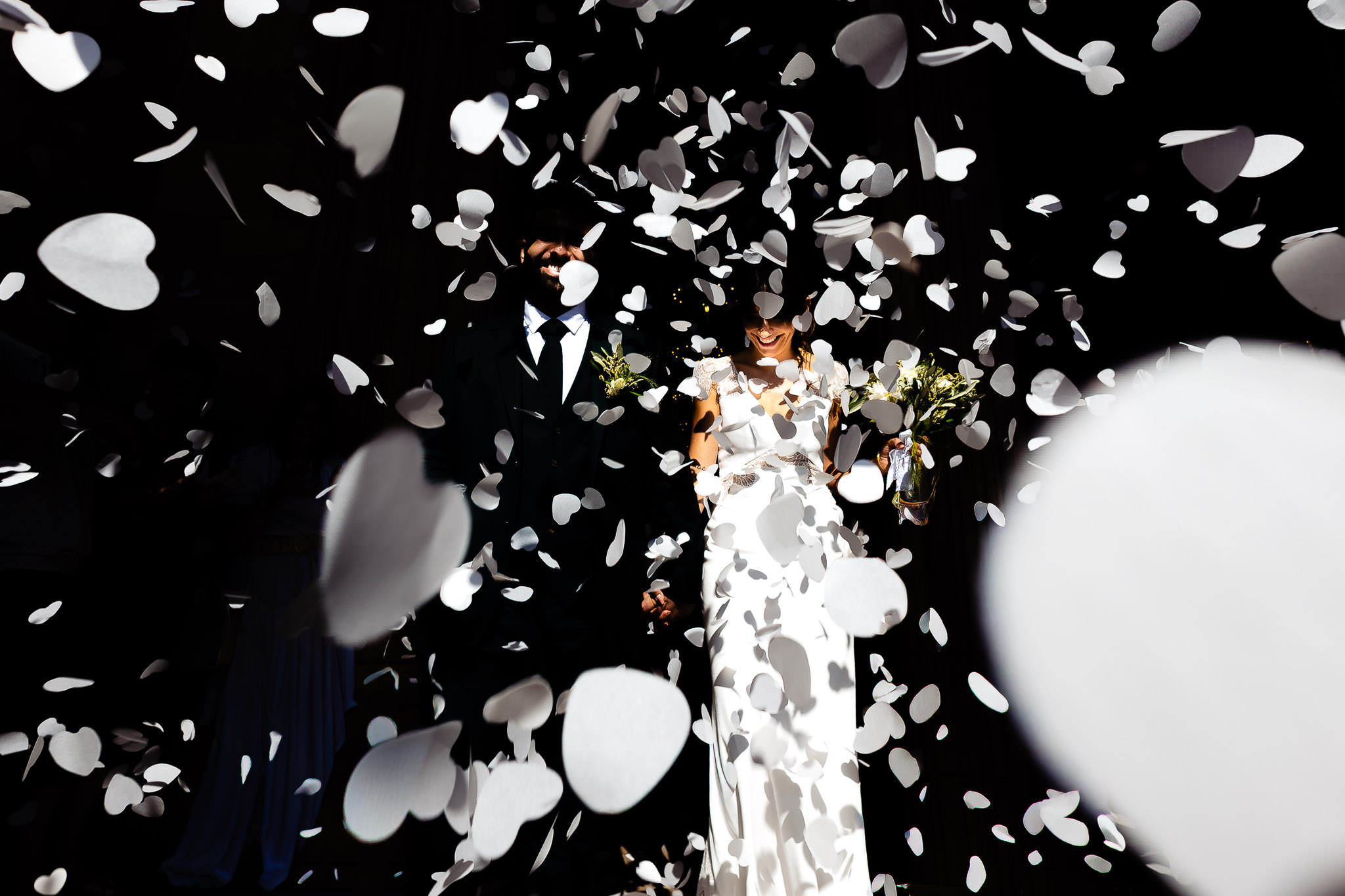 Photographe de mariage — mariés sous un lancer de confettis en cœur